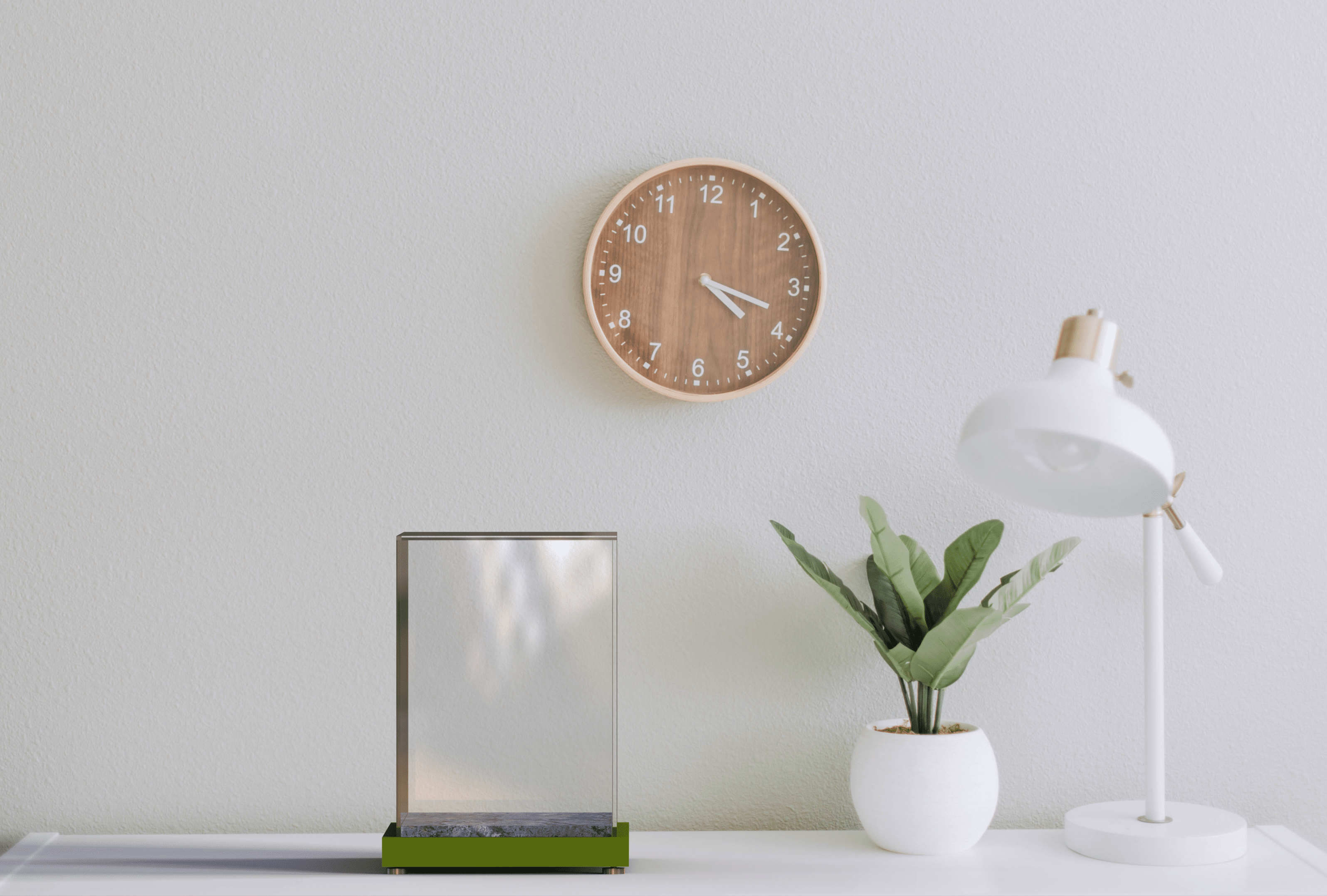 Tableau, horloge murale, plante et lampe blanche.
